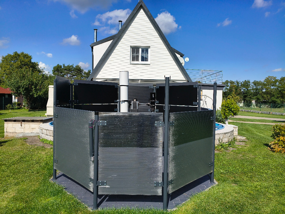 Tak jsem si “vyrobil soukromou tmu”. 	Ohrazení terasy odnímatelnými panely.<br />	Sloupky TR 51 x 3  - 2000 mm s 	navařenými háčky PR 6 mm. <br />	Závěsy P 0,6 – 55 x 113 mm.<br />	Panely komůrkový makrolon 10 mm.<br />	Rozměry panelů 1050 mm x 1200 mm a 	1050 mm x 800 mm (dolní řada, 4 + 4).<br />	Rozměry panelů 520 mm x 1200 mm a 	520 mm x 800 mm (horní řada, 4 + 4).<br />	Panely jsou cca 210 mm od dlažby.<br />	Odkládací lavička je ze záhonových 	obrubníků 200 x 50 x 1000 mm.<br />	Tvar ohrazení je osmiúhelník.<br />Horní hrana dolních panelů je cca 1260 mm.<br />	Horní hrana horních panelů je cca 1800 mm.<br />	Jeden sloupek na jižní straně je dělený pro 	umožnění pozorování při sklonu 5˚.<br />	Panely jsou opatřeny nátěrem (antracit) a 	částečně černou samolepící folií.<br />	Natřít jsem musel i dlažbu – odrážela mi 	světlo do očí zespod.<br />	Účinnost ohrazení ohledně “mikrotmy” mne 	mile překvapila, také vítr je znatelně slabší.
